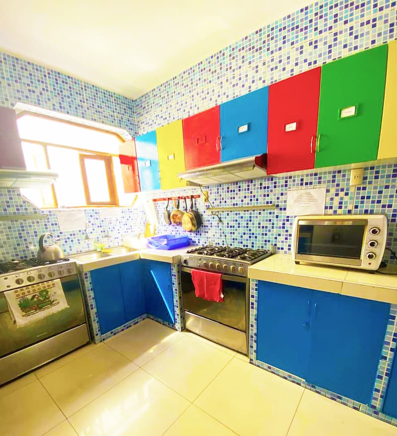 Fully equipped shared kitchen with colorful cabinets at Casa Yllika student housing Jesus Maria Lima Peru