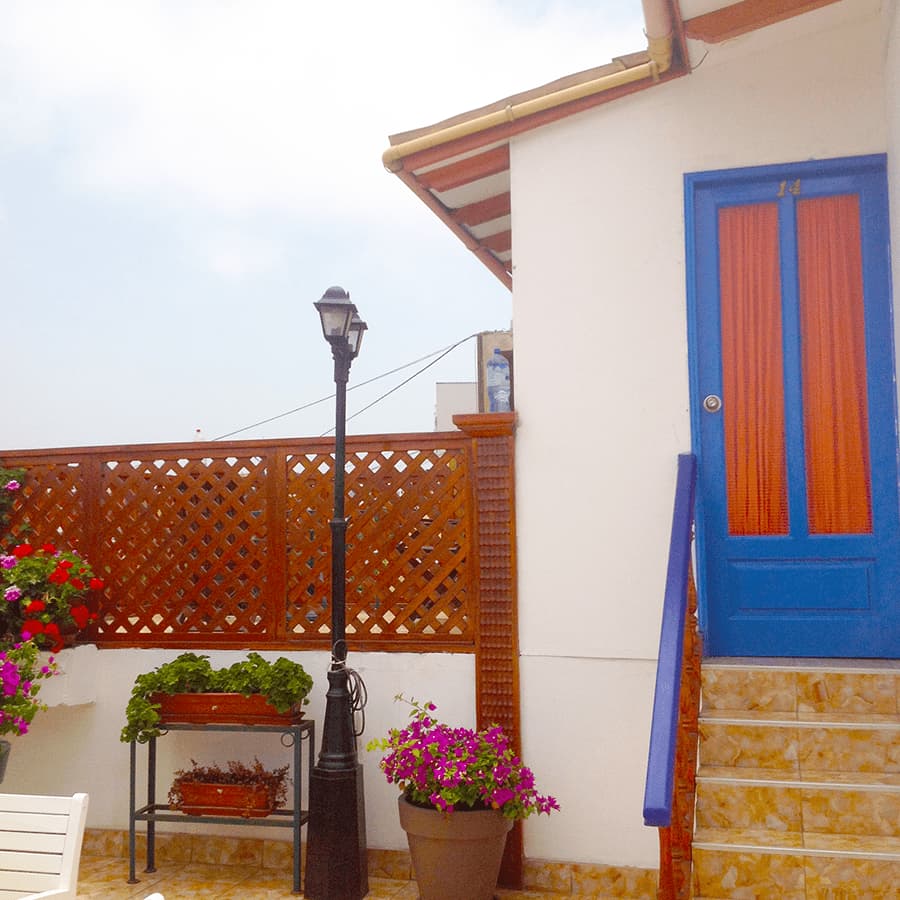 Colorful rooftop entrance with blue door and flowers at Casa Yllika student housing Jesus Maria Lima Peru