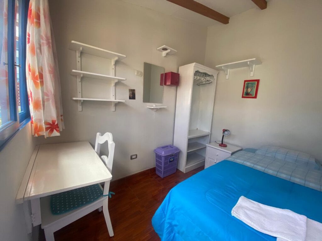 Fully furnished student room with desk, wardrobe and shelves at Casa Yllika student housing Lima Peru