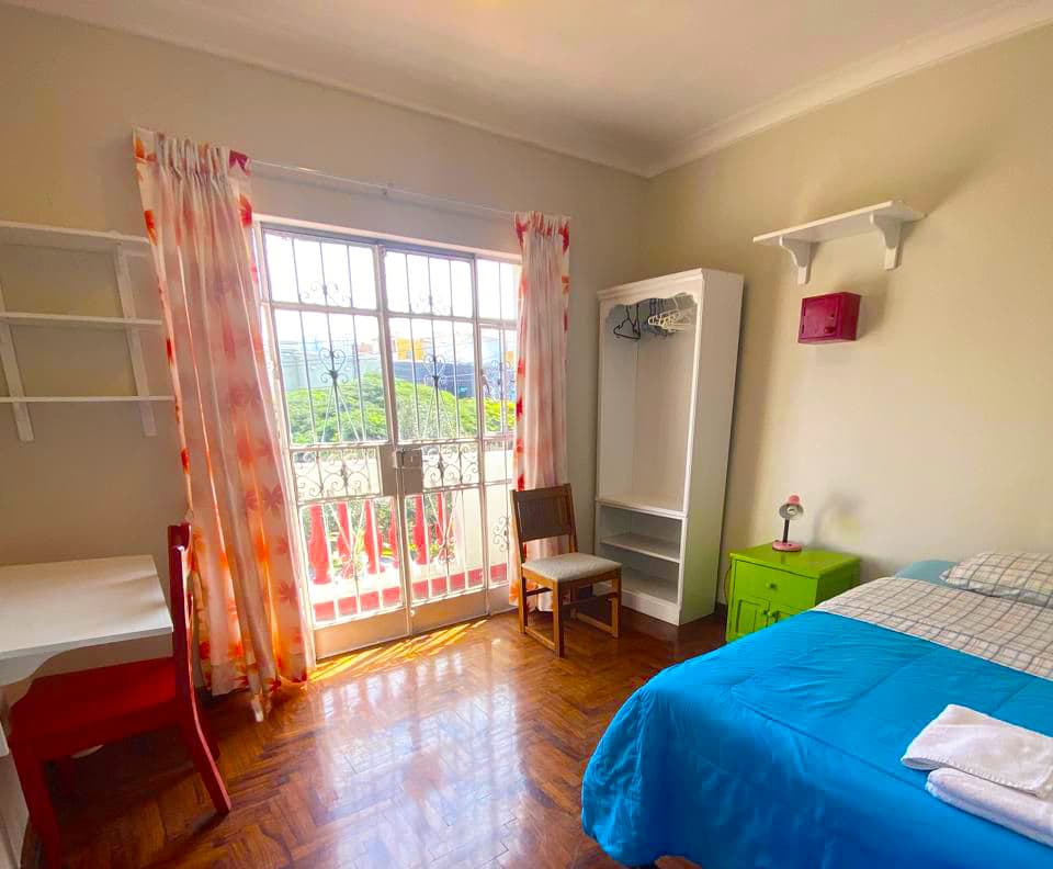 Bright private student room with balcony and garden view at Casa Yllika student housing Jesus Maria Lima Peru